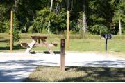 Close-up photo of the brown with white site number sign on a wooden post.