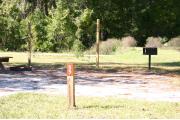 Close-up photo of the brown with white site number sign on a wooden post.