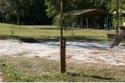 Close-up photo of the brown with white site number sign on a wooden post.