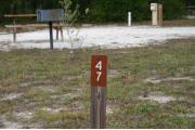 Close-up photo of the brown with white site number sign on a wooden post.