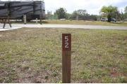Close-up photo of the brown with white site number sign on a wooden post.
