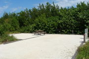 Photo: 002, View of gravel campsite with picnic table and grill.