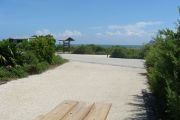 Photo: 012, View looking out from back of site to campground road. Kiosk and beach access in background.