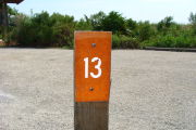 Photo: 013, View of site number post white on brown, bushes visible in the back ground.