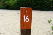 Photo: 016, View of site number post white on brown, bushes visible in the back ground.