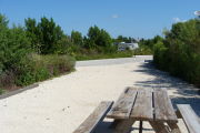 Photo: 016, View looking out from back of site over picnic table to campground road. . RV and bushes in background.