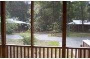Looking out from the front of this cabin is a view of cabins 2 and 3 which are separated by a patch of vegetation. The side and rear view from the cabin is of a hardwood hammock beyond a narrow open area between the woods and the cabins. In back is a picnic table and grill.