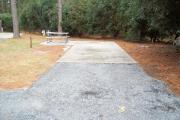 A view of RV site three at Topsail Hill Preserve State Park looking towards the back of the site.  A picnic table is on a concrete pad to the left of the site.