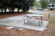 A view of RV site three at Topsail Hill Preserve State Park looking towards the front of the site.  A picnic table is on a concrete pad to the right of the site.