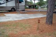 A view of RV site four at Topsail Hill Preserve State Park showing the site marker and a picnic table next to the site.