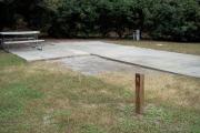 A view of RV site five at Topsail Hill Preserve State Park showing the site marker, a picnic table next to the site, and the utility hook up boxes.