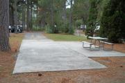 A view of RV site twenty-nine at Topsail Hill Preserve State Park looking towards the front of the site.  A picnic table is on a concrete pad to the right of the site.