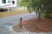 A view of RV site thirty-one at Topsail Hill Preserve State Park showing the site marker to the right of the site and a neighboring RV to the left of the site.