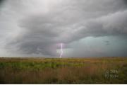 Gray clouds accumulate during the summer and create impressive thunderheads.  Lightning strikes the ground of the treeless prairie.