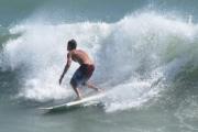 A surfer is enjoying the ride on a wave along the beach at the park.