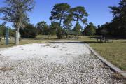 Photo: 13, Loop B. View of campsite with electric and water hookup. A picnic table can be seen in the background.