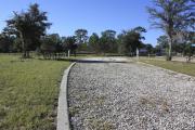 Photo: 13, Loop B. View of campsite with electric hookup. A picnic table can be seen in the background.