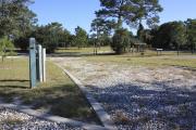 Photo: 14, Loop B. View of campsite with electric hookup. A picnic table can be seen in the background.