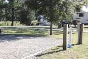Photo: 002, SANTOS CAMPGROUND. View of campsite with water and electric hookups and picnic table with fire ring.