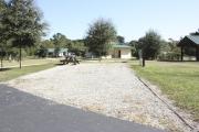 Photo: 011, SANTOS CAMPGROUND. View of campsite with water and electric hookups and picnic table with fire ring. Campground facilities can be seen.