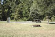 Photo: 011, SANTOS CAMPGROUND. View of campsite with water and electric hookups and picnic table with fire ring.