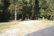 Photo: 012, SANTOS CAMPGROUND. View of campsite with water and electric hookups and picnic table with fire ring.
