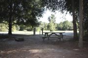 Photo: 018, SANTOS CAMPGROUND. View of campsite with water and electric hookups and picnic table with fire ring.