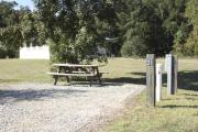 Photo: 021, SANTOS CAMPGROUND. View of campsite with water and electric hookups and picnic table with fire ring.