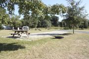 Photo: 021, SANTOS CAMPGROUND. View of campsite with water and electric hookups and picnic table with fire ring.