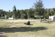 Photo: 023, SANTOS CAMPGROUND. View of campsite with water and electric hookups and picnic table with fire ring.
